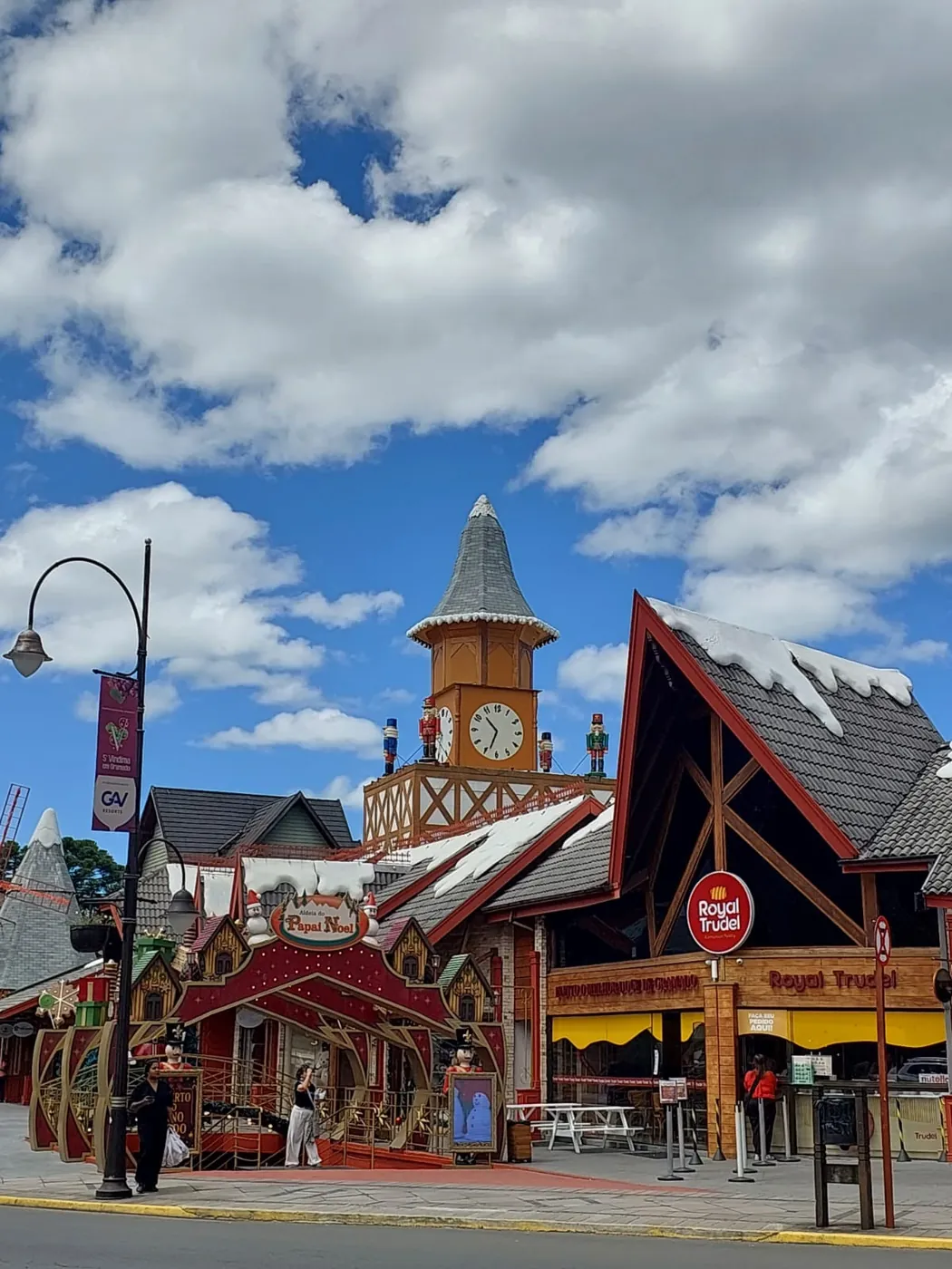 Loja de rua Royal Trudel em Gramado, com telhado em A, ao lado da torre do relógio da cidade