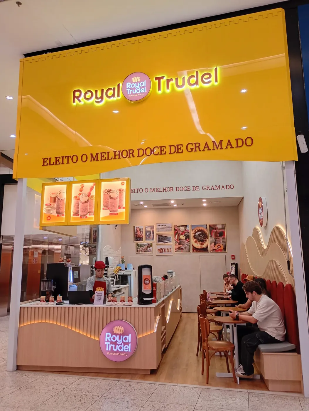 Loja Royal Trudel em shopping, com fachada amarela e balcão de atendimento