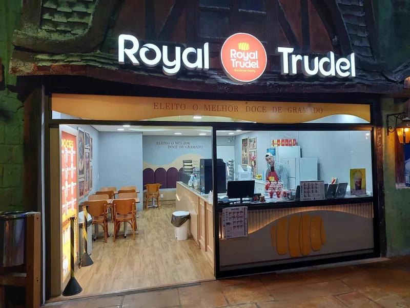 Loja Royal Trudel dentro de um parque temático, com fachada temática e letreiro iluminado