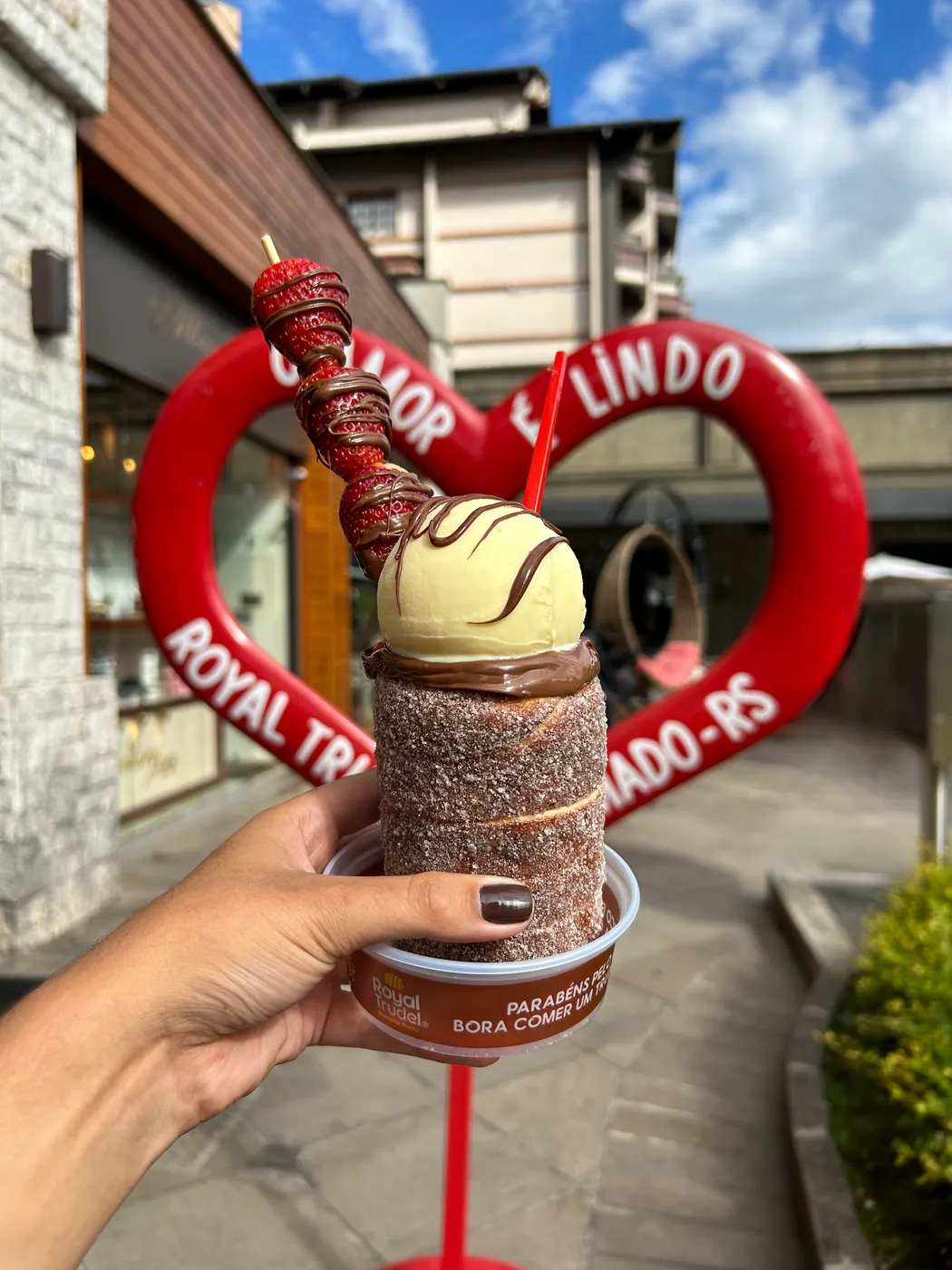 Trudel sendo segurado diante do coração 'O amor é lindo' da Royal Trudel em Gramado